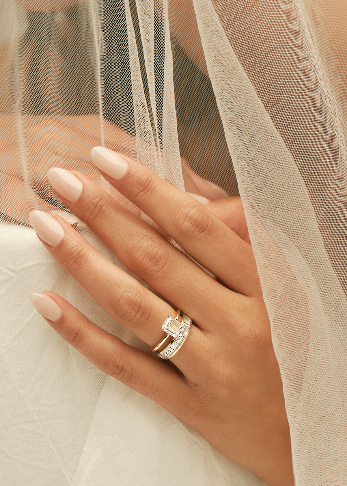 Close-up of a hand wearing a diamond ring with a blurred background