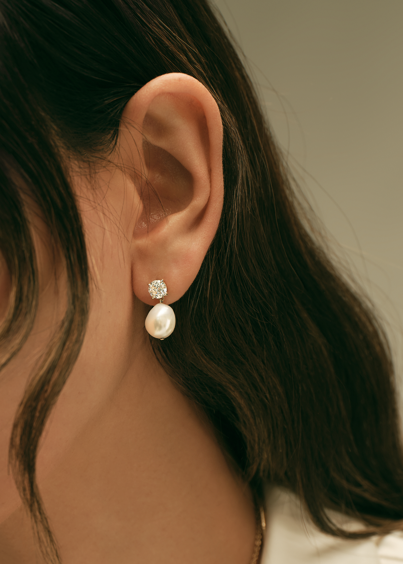 close up of an ear wearing Kinn Studio 14k Gold Delanie Diamond Baroque Pearl Earrings