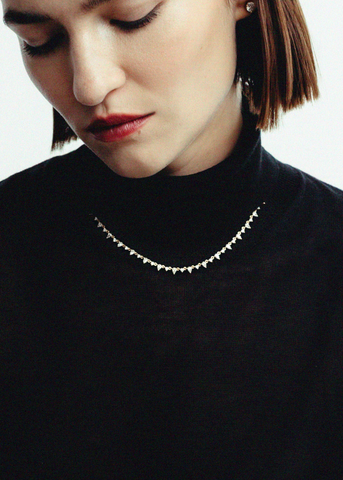 woman in a black turtleneck wearing a Kinn 14k Gold Juliette Diamond Row Necklace