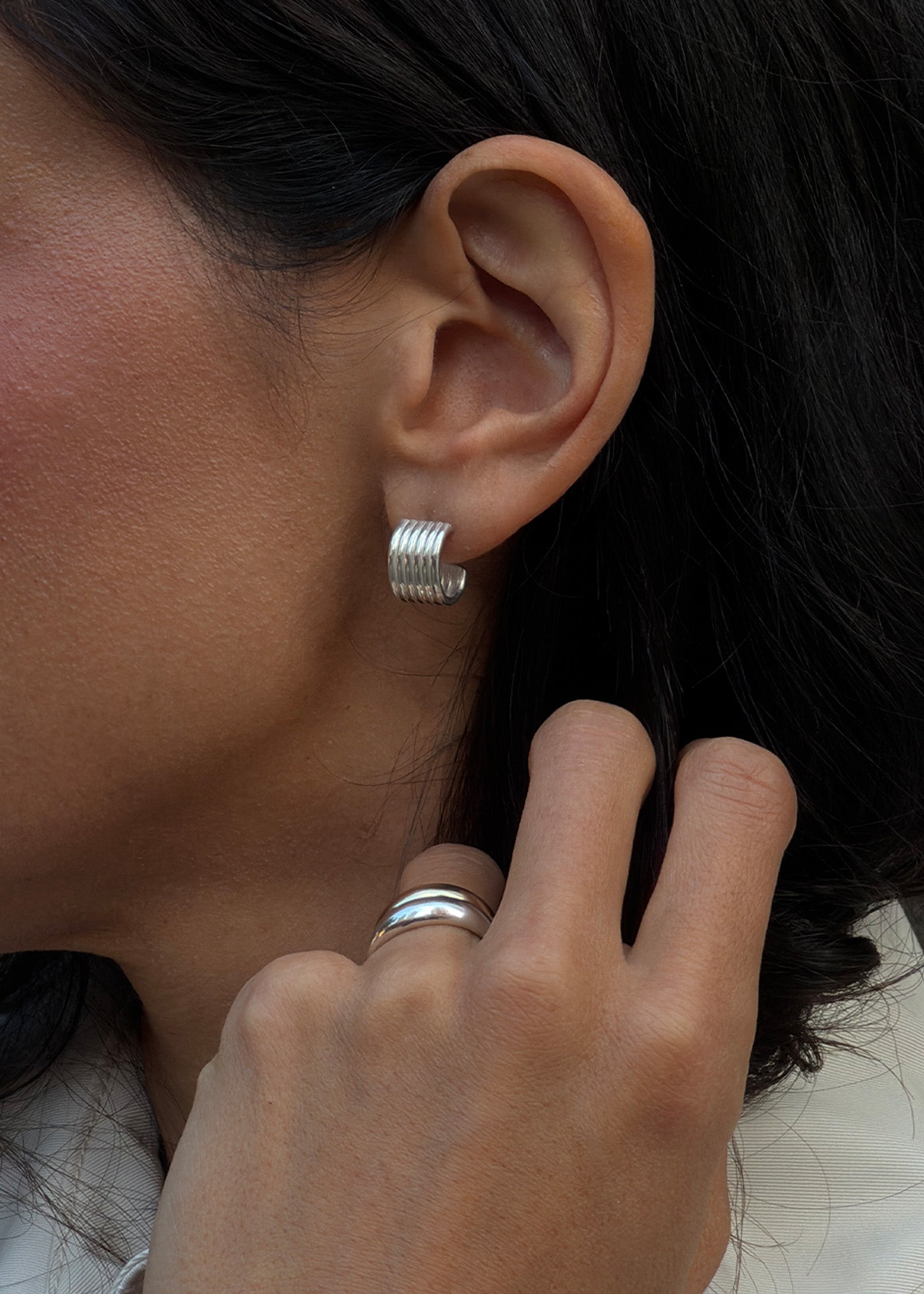 close up of a woman's ear wearing Kinn Studio 925 Sterling Silver Mercer Cuff Hoop Earrings