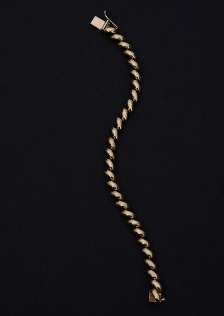 A Kinn Studio 14k Gold Hampshire House Bracelet laid flat against a black background