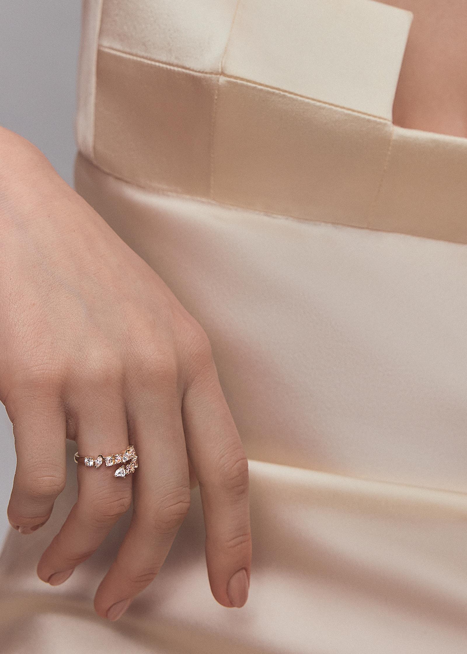 close up of a woman's hand wearing a Kinn 14k Gold Aria Fancy Cut Diamond Wrap Around Ring on her ring finger