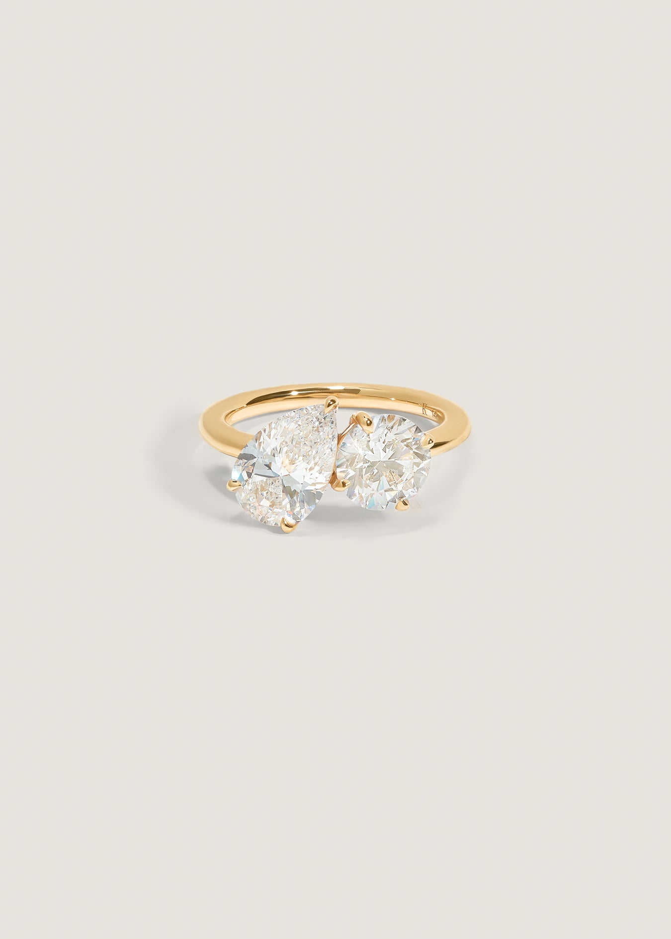 A Kinn 14k gold Toi et Moi Annette Engagement Ring featuring a pear shaped diamond and a round diamond