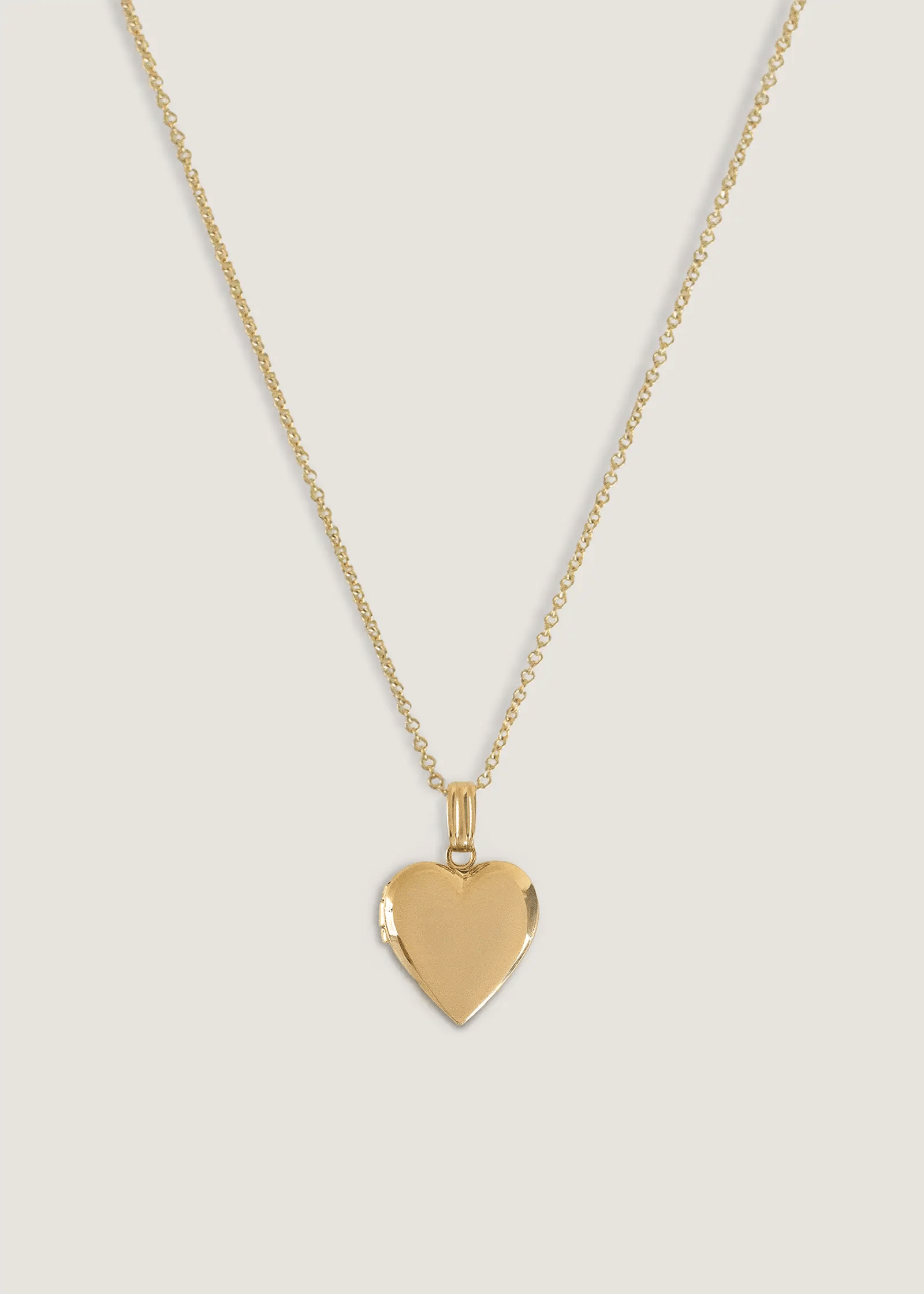 Gif of a Kinn 14k gold Maison Heart Locket Necklace opening up and showing a photo inside